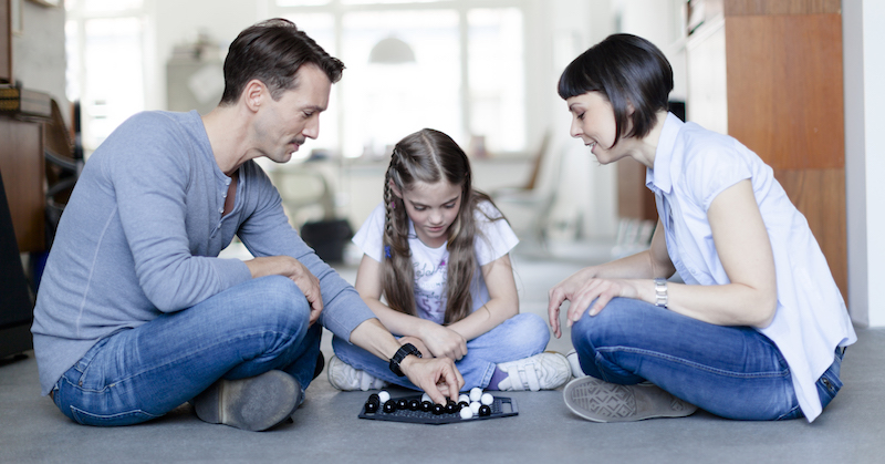 Young family is playing board-game